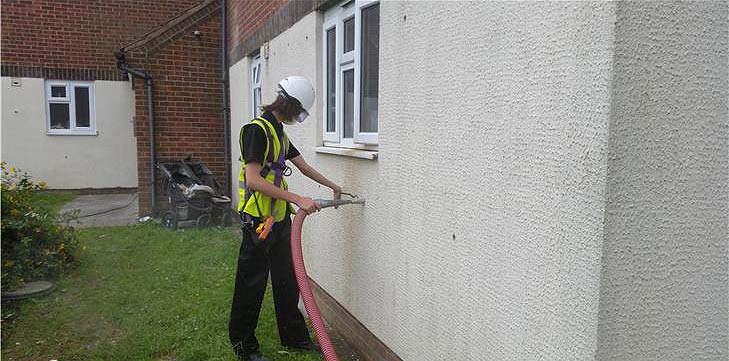Wall being injected with insulation material Wall being injected with insulation material